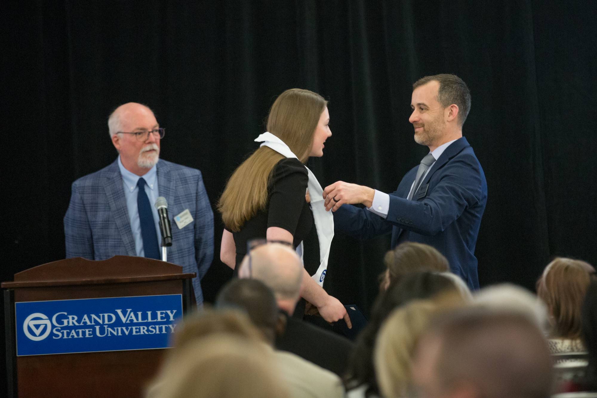 Honors graduate smiles while receiving their stole